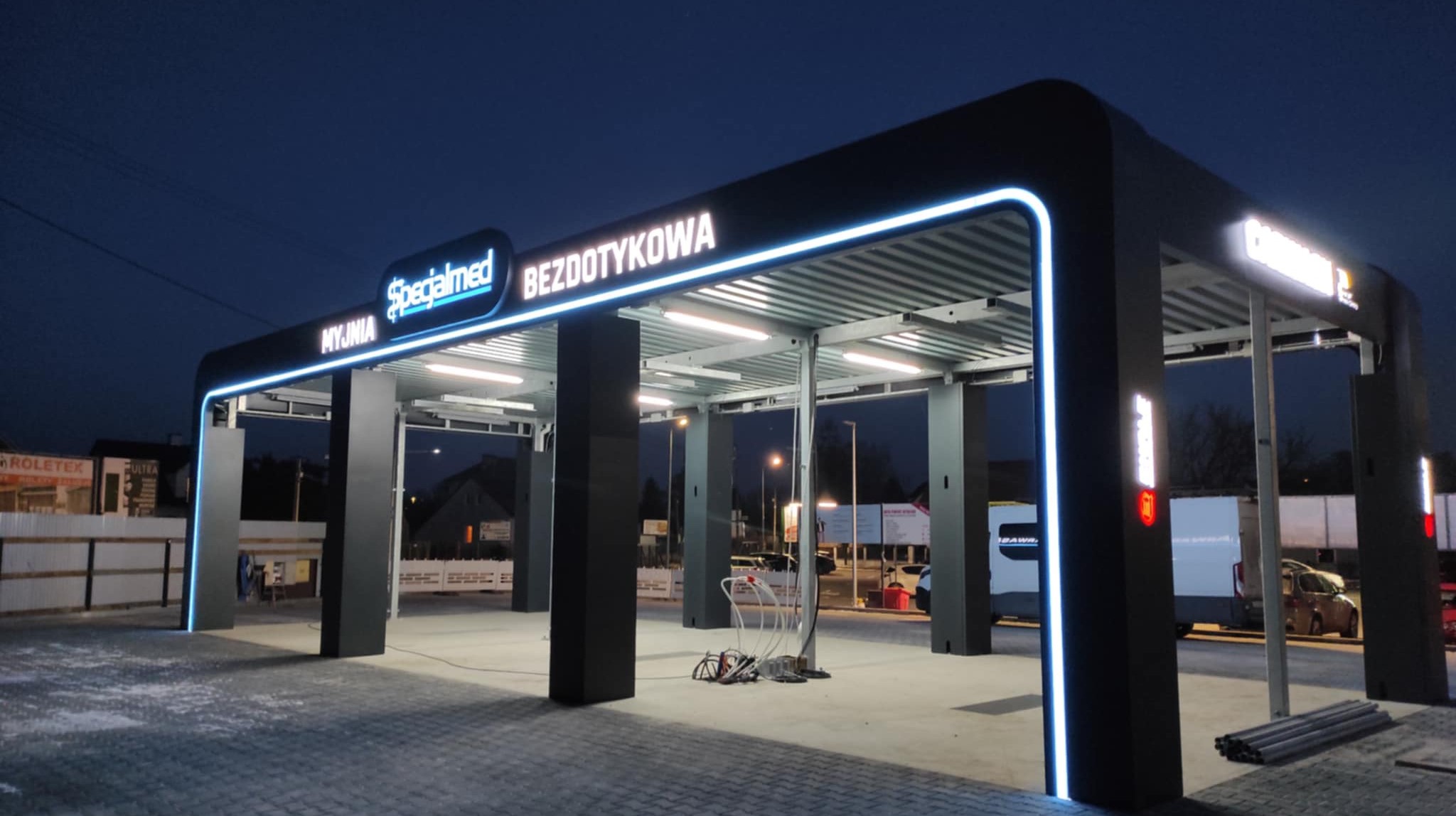 Bezdotykowa myjnia Prestige Plus samochodowa z podświetleniem w nocy, z widocznymi stanowiskami do mycia.